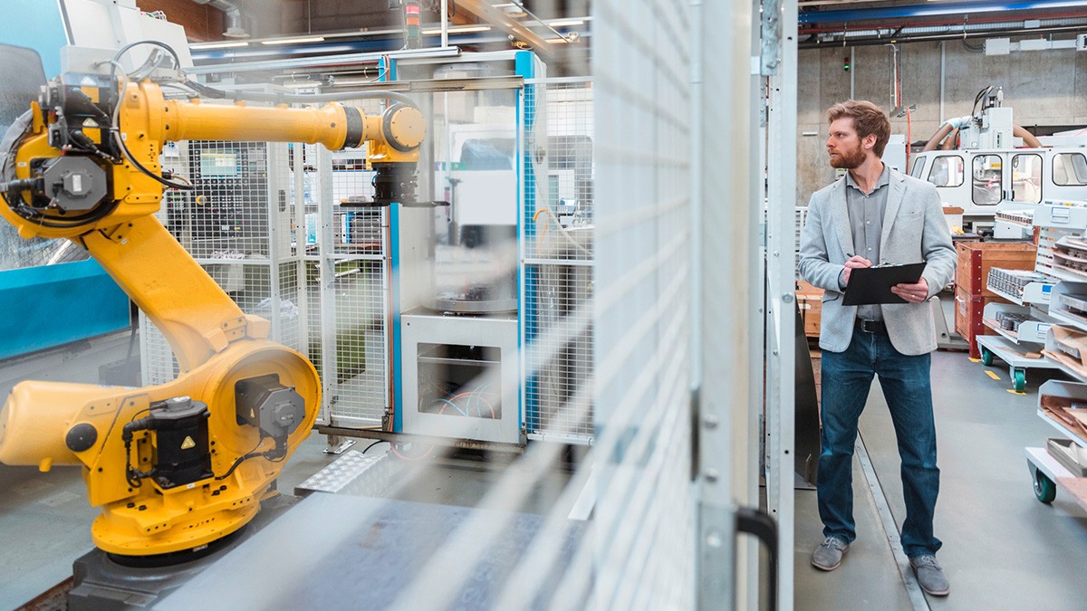 Ingenieur überwacht Industrieroboter in der automatisierten Fertigung